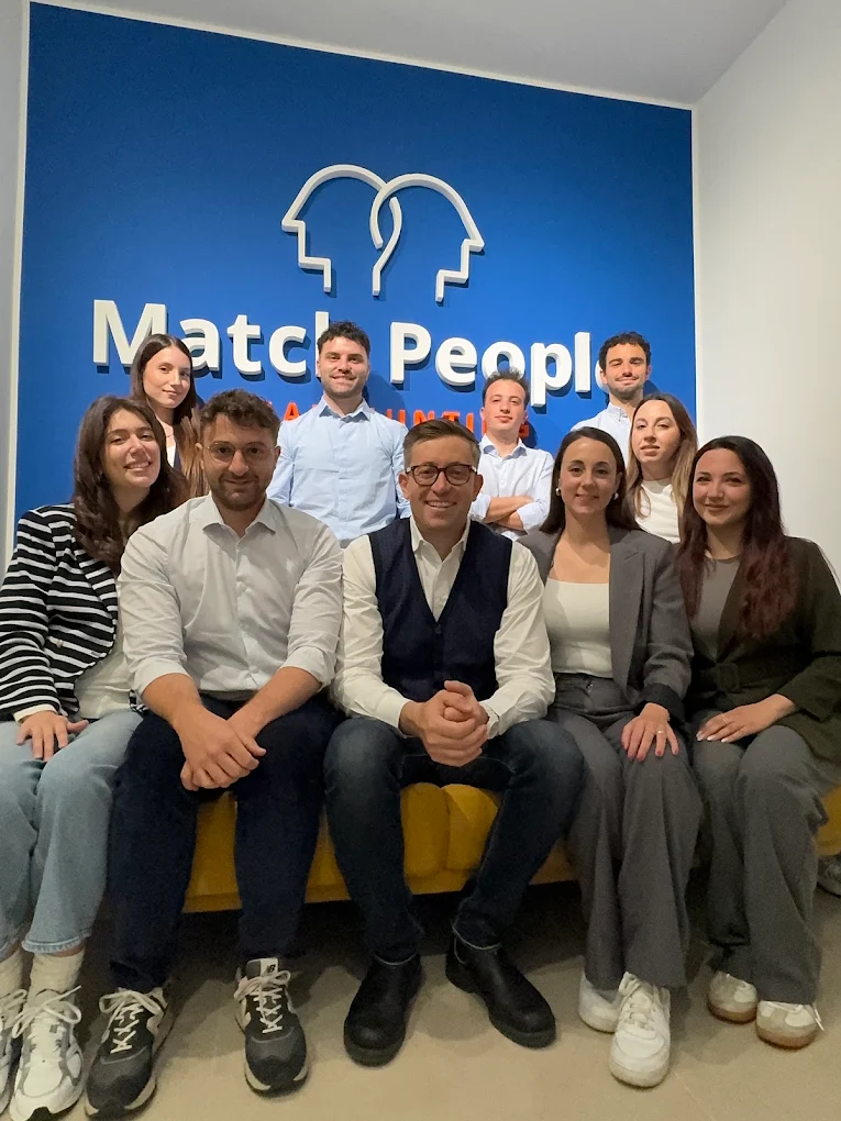 Il team Match People davanti alla parete brand